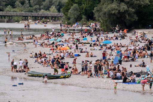 06 July 2019, Bavaria, Munich: Holidaymakers lie on the banks of the Isar in the evening. Photo: Matthias Balk\/