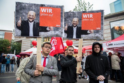 Protesters of the satirical party "The Party" hold up poster of SPD candidate for Chancellor with thumbs up that read "WE give up" at an SPD election campaign event in Muenster, Germany, 06 September 2017. Photo: Guido Kirchner\/