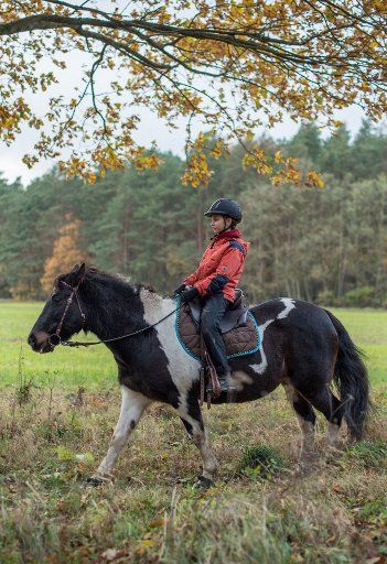 Eleven-year-old Amy rides on pony Gipsy through a forest in Sieversdorf, Germany, 19 November 2017. Photo: Patrick Pleul\/dpa-Zentralbild\/