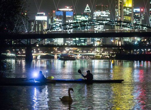 Paddlers flow on the Main river and can be seen in front of the banking skyline in Frankfurt am Main, Germany, 21 Novemebr 2017. Photo: Frank Rumpenhorst\/