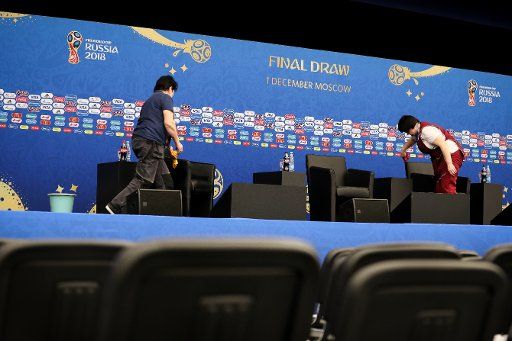 Cleaners prepare the seats on the podium for a discussion panel with FIFA President Infantino and Russia\