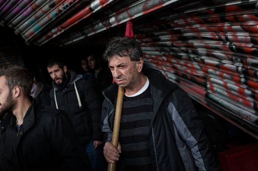 Members of the Greek Communist labour union exit from a broken entrance of the Greek labour ministry during a demonstration against the government·s decision to amend the law on strikes, in Athens on December 5, 2017. State employees have laid down their work for three hours in protest of the labour law changes. Photo: Angelos Tzortzinis\/DPA\/