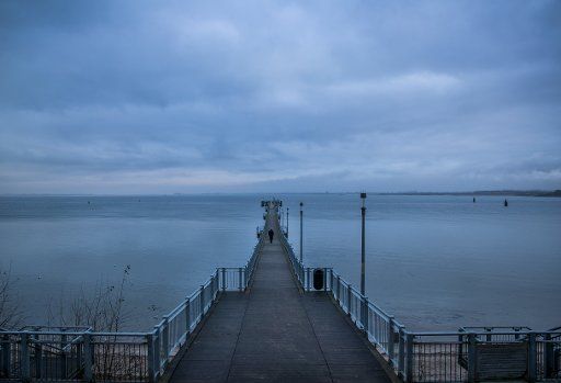 A man walks on the pier in Wendorf near Wismar, Germany, 20 December 2017. Fog and light rain created an uncomfortable weather shortly before Christmas in Northern Germany. Photo: Jens Büttner\/dpa-Zentralbild\/