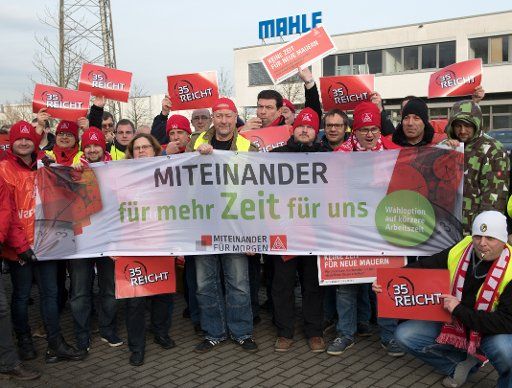 IG Metall workers demonstrating during a warning strike in front of the gates of the factory Mahle Filtersysteme in Wustermark, Germany, 09 January 2018. About 430 metalworkers underlined their demands with warning strikes of up to two hours on Tuesday. Photo: Ralf Hirschberger\/