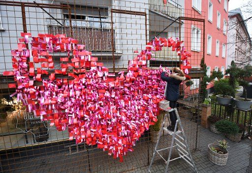 Helena Meckbach forms a giant heart out of red ribbons on a metal gate in front of the flower shop "Bluetesiegel" in the area Sachsenhausen in Frankfurt am Main, 23 January 2018. About 2700 ribbons and three days of work were necessary to create the piece that points to 14 Febuary 2018, Valentine\