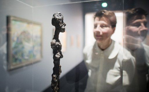 20 February 2018, Germany, Hanover: Carina Plath, curator for painting and sculpture, stands behind a replica of a Giacometti sculpture at the exhibition \