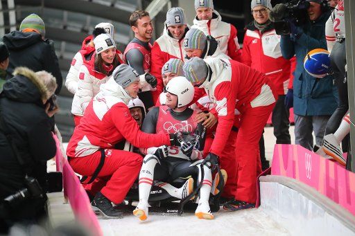 14 February 2018, Sout Korea, Pyeongchang: Olympic, Doubles Luge, Men, Alpensia Sliding Centre: Peter Penz and Georg Fischler (L) of Austria celebrate with their team at the finish line. Photo: Michael Kappeler\/