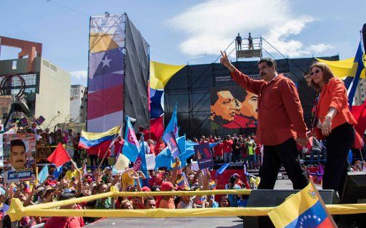 President Nicolas Maduro (L) and his wife Cilia Flores (R) appearing in front of supporters during a rally in the capital Caracas, Venezuela, 27 February 2018. The couple danced for the crowd after Maduro registered himself as candidate for the contested presidential election to take place on 22 April 2018. Photo: Rayner Pena\/
