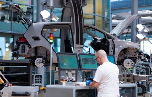 12 March 2018, Germany, Dresden: A Volkswagen employee works at the assembly of a VW e-Golf at the \
