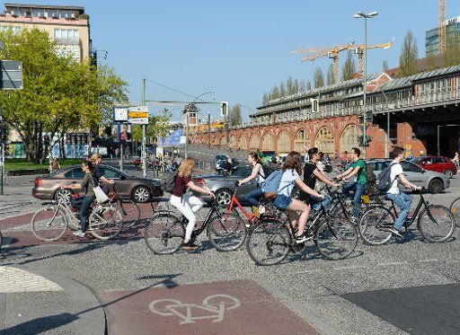 18 April 2018, Germany, Berlin: Several cyclists and cars at the crossroads of Muehlen Strasse and Warschauer Strasse by the Oberbaumbruecke bridge. Photo: Jens Kalaene\/dpa-Zentralbild\/