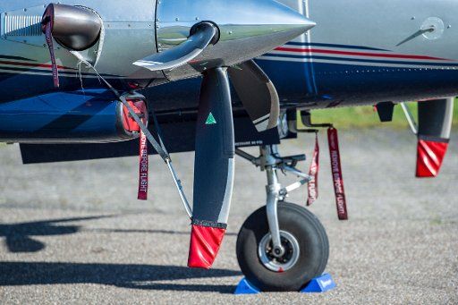 21 April 2018, Germany, Norderney: A roll-away lock and different safety devices are fixed to a parked small propeller aircraft at the airfield. Photo: Lino Mirgeler\/