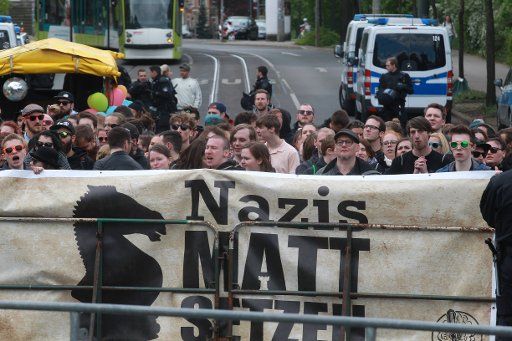 01 May 2018, Germany, Erfurt: Police officers standing before a group of left-wing counter-protesters at the Main Station. About 700 members of the right-wing scene took part in the NPD\