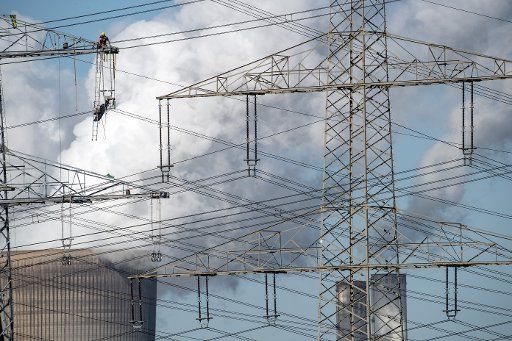 08 May 2018, Germany, Ingendorf: Workers mounting powerlines under a blue sky. Photo: Federico Gambarini\/