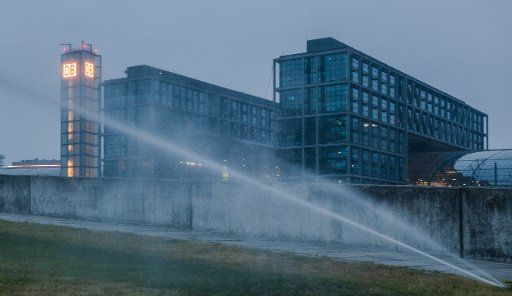 11 May 2018, Germany, Berlin: Water is sprayed across a lawn outside the central railway station. Photo: Paul Zinken\/