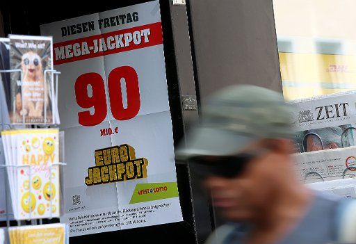 24 May 2018, Germany, Cologne: A poster announcing a lottery jackpot of 90 million euros outside a shop. Photo: Oliver Berg\/
