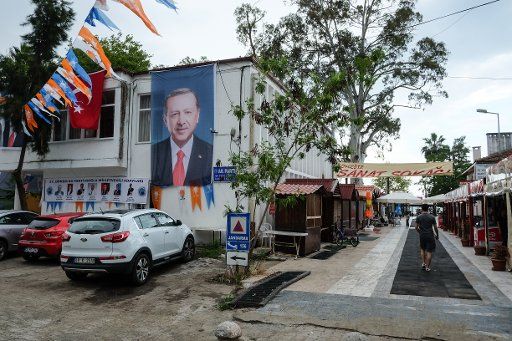 29 May 2018, Turkey, Koycegiz: A photo of Turkish President Recep Tayyip Erdogan hangs attached to the wall of a building with pennats featuring the emblem of Erdogan\