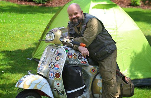 14 June 2018, Germany, Kempten: Markus Mayer sits on his modified Vespa from the year 1979. The 41 year old wants to drive around the world on his scooter in 80 days. Photo: Karl-Josef Hildenbrand\/