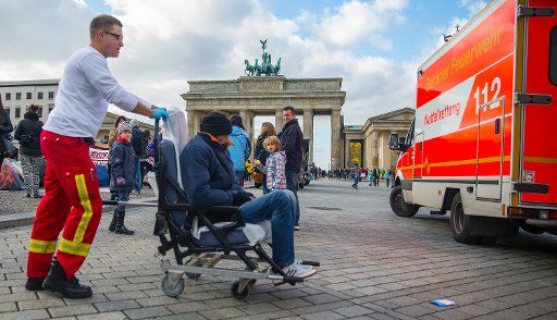 A refugee is treated by rescue workers at Pariser Platz in front of the Brandenburg Gate in Berlin, Germany, 18 October 2013. The refugees have been on a hunger strike since 09 October. Photo: