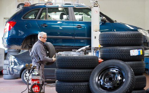 In a tire workshop, Klaus-Peter Arnold removes the summer tires of a car to put on winter tires in Frankfurt Oder, Germany, 14 October 2013. According to experts, car drivers should start using winter tires when the temperature dorpped below seevn ...