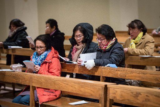 Philippines attend a service for the Philippine community at the Kleiner Michel church in Hamburg, Germany, 13 November 2013. Filipinos abroad fret about their families and friends after the typhoon \