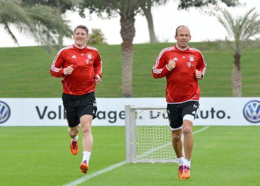 Arjen Robben (L) and Bastian Schweinsteiger of FC Bayern Munich run during the training in Doha, Qatar, 06 January 2014. The training camp in Qatar continues until 13 January 2014. Photo: Peter Kneffel\/