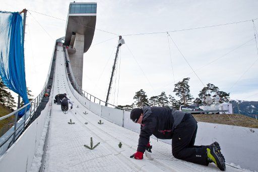 Workers prepare the inrun of the ski jump at the third stage of the Four Hills ski jumping tournament in Innsbruck, Austria, 03 January 2014. Photo: DANIEL KARMANN\/