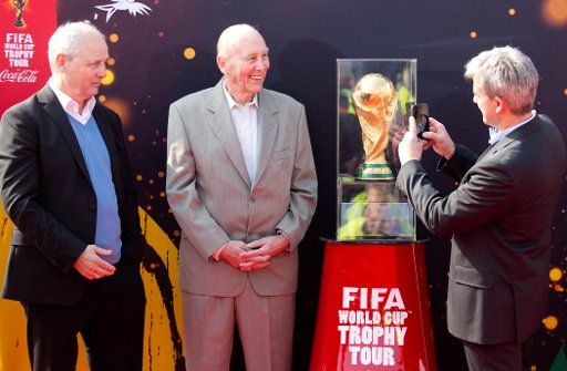 The former football nationalplayers and world champions Horst Eckel (1954, L-R), Bernd Hoelzenbein (1974) and Pierre Littbarski (1990) present the original Fifa world champion trophy at the airport in Berlin-Tegel, Germany, 29 March 2014. The trophy ...