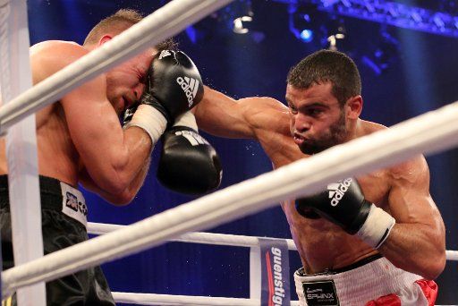 The Tunisian Soufiene Ouerghi (R) and German Dominik Britsch (L) during the middleweight boxing bout in Rostock, Germany, 05 April 2014. Ouerghi wins the fight with 12 points. Photo: Bernd Wuestneck\/