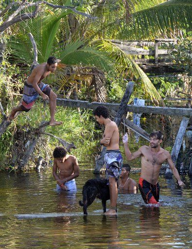 Young people swim in a small lake in Santa Cruz Cabralia, Brazil, 13 June 2014. The FIFA World Cup will take place in Brazil from 12 June to 13 July 2014. Photo: Marcus Brandt\/