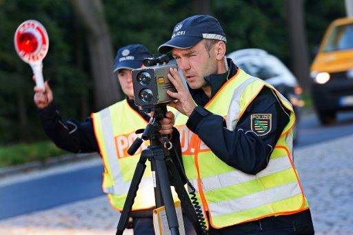 Police commissioner Lars Fechtner (L) and police officer David Wortha work a laser speed camera in Dresden, Germany, 18 September 2014. The police intends to sensitize road users to drive according to regulations with a 24-hour German-wide speed ...