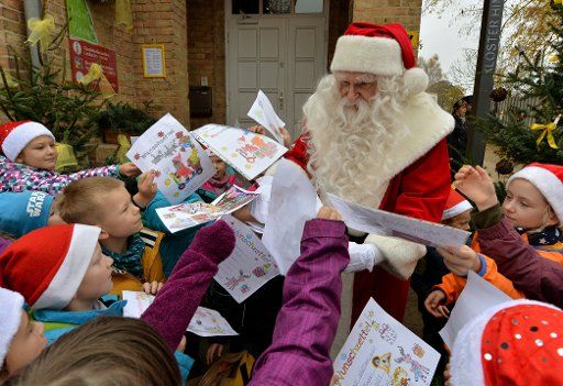 Santa hands out sweets to Bredereiche Elementary School pupils for the opening of the Christmas Post Office in Himmelpfort, Germany, 06 November 2014. For 30 years, letters addressed to "Weihnachstmann 16798 Himmelpfort" are answered and sent back. ...