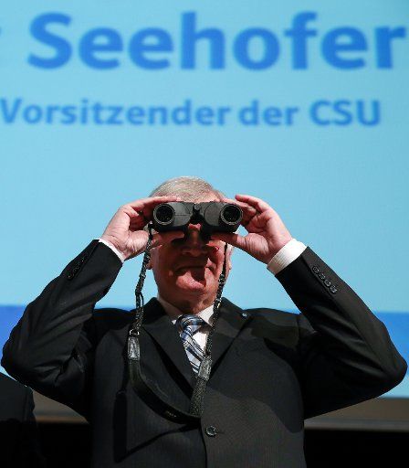 Bavarian Premier Horst Seehofer is handed a set of binoculars during the Bavarian middle-class day for the Christian Social Union\