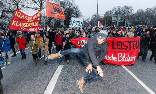 A student break dances in front of a demonstration in Hamburg, Germany, 09 December 2014. Members of the Hamburg colleges demonstrated for improved financial committments to their institutions. Photo: MARKUS SCHOLZ\/