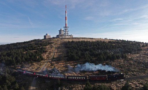 A view of the Brocken while a steam locomotive from the Harz Narrow Gauge Railway rides through the autumn landscape in Schierke, Germany, 23 November 2014. Despite a short cold spell, Winter has not yet arrived to the Harz mountain peak. The ...