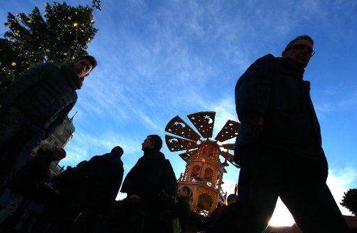 In sunny weather, people walk across the Christmas fair in Augsburg, Germany, 23 December 2014. One day before Christmas Eve, the weather in Southern Bavaria is mild and sunny. PHOTO: KARL-JOSEF HILDENBRAND\/
