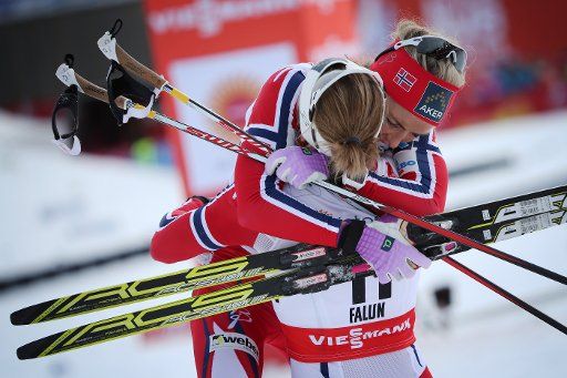 Therese Johaug (right) of Norway celebrates after winning the women\
