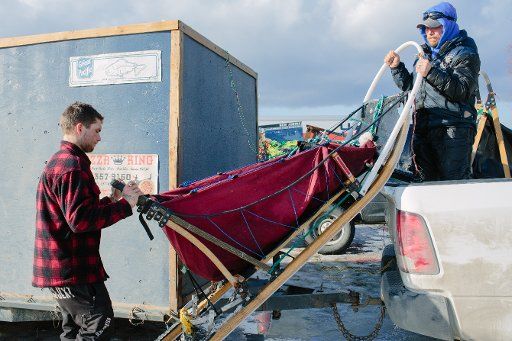 Jason Mackey (right) loads a dog sled in the back of a truck following the Ceremonial Start of the 2015 Iditarod Dog Sled Race at Anchorage (USA) on March 7, 2015. The race will resume with the official start in Fairbanks on March 9. Photo: Joshua ...