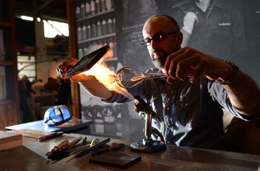 Glass blower Frank Liebmann produces a whiskey glass on the International Craft fair in Munich, Germany, 12 March 2015. The native Thuringian usually does performances of glassblowing in the German Museum in Munich. Photo: ANDREAS GEBERT\/