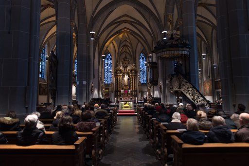 People sit before a church service with the airport and emergency pastoral carers in the St.-Lambertus-Kirche in Duesseldorf, Germany, 27 March 2015. A Germanwings Airbus A320 crashed in the French Alps on 24 March 2015. PHOTO: MARIUS BECKER\/