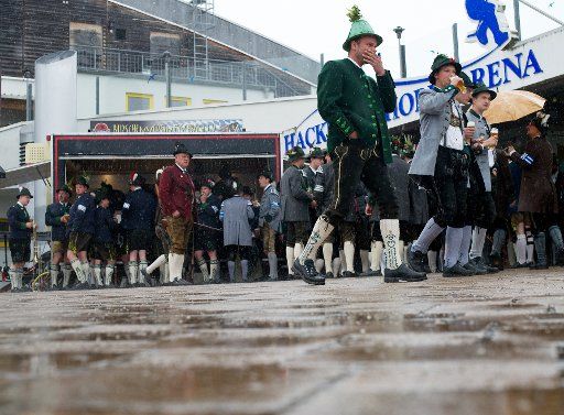 Two Bavarian mountain marksmen dressed in traditional clothing walk through rain during the traditional Patronage day of Bavarian mountain marksmen in Bald Toelz, Germany, 3 May 2015. Photo: Around 4,000 marksmen are gathering for the traditional ...