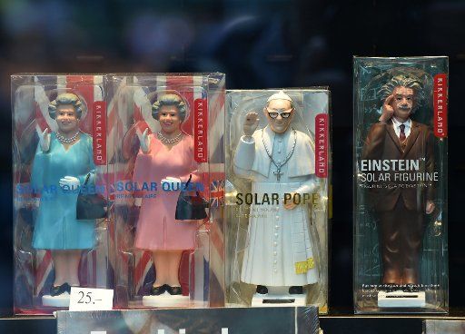 Waving solar figures from the Queen (l-r), the Pope, and Albert Einstein on sale for 25 Euros in a shop window in Berlin, Germany, 09 June 2015. Photo: Jens Kalaene\/