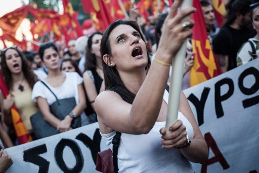 dpatopbilder A member of the Greek Communist Party Youth waves a flag a rally in Athens, Greece, 02 July 2015, against the EU and the Greek Government in Athens, ahead of the referendum on 05 July 2015 when Greek voters will be asked whether the ...