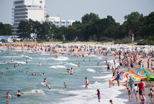 Many people go for a swim or enjoy the sunny weather in Timmendorfer Strand, Germany, 17 July 2015. Photo: DANIEL BOCKWOLDT\/