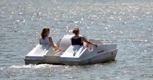 Two women ride in a pedal boat on Aasee lake in Muenster, Germany, 17 July 2015. Photo: Caroline Seidel\/