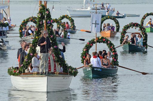 Boats decorated with flower wreaths sail during the Water Procession of Moos on Lake Constance into the harbor of Radolfzell, Germany, 20 July 2015. The procession takes place annually on the third Monday of July since 1926 and is a thanksgiving for ...