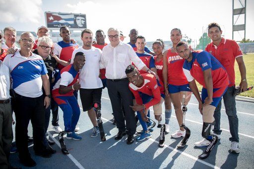 German Foreign Minister Frank-Walter Steinmeier (SPD) standing next to Paralympic champion Heinrich Popow (l) and Hans-Georg Naeder, manager of the prosthetics manufacturer Otto Bock (3.f.l.) during a training session of the Cuban Paralympic team in ...