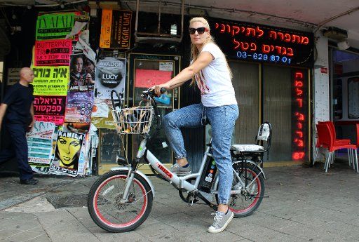 Schulamit Babliki rides her e-bike through Tel Aviv, Israel, 13 July 2015. The 39-year-old, who imigrated from Lithuania in 1991 is one of thousands of Israelis who use e-bikes. Photo: Sara Lemel\/