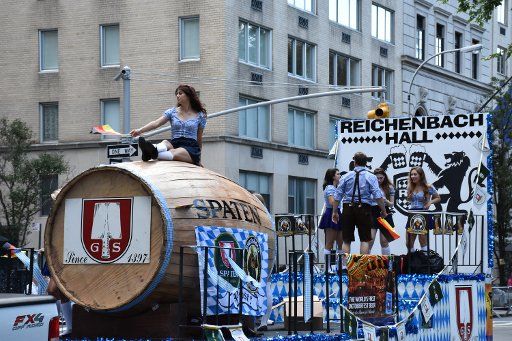 A woman sits on a giant beer keg during the Steuben Parade in New York, USA, 19 September 2015. The traditional parade on Fifth Avenue in Manhattan is considered the largest event held by German Americans. Photo: Chris Melzer\/