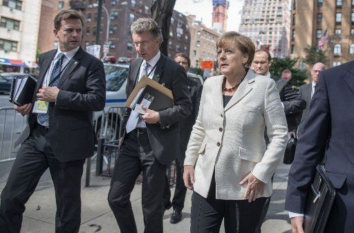 German Chancellor Angela Merkel (front R) talks to Steffen Seibert (L), spokesperson for the German government, and her foreign policy advisor Christoph Heusgen (front C) as they walk toward the premises of the United Nations in New York, USA, 26 ...