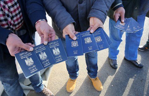Transit refugees display their passports (from Iraq and Syria), which they must present in order to purchase tickets for a ferry to Sweden, in the seaport of Rostock, Germany, 12 November 2015. Due to the large number of refugees, Sweden has ...